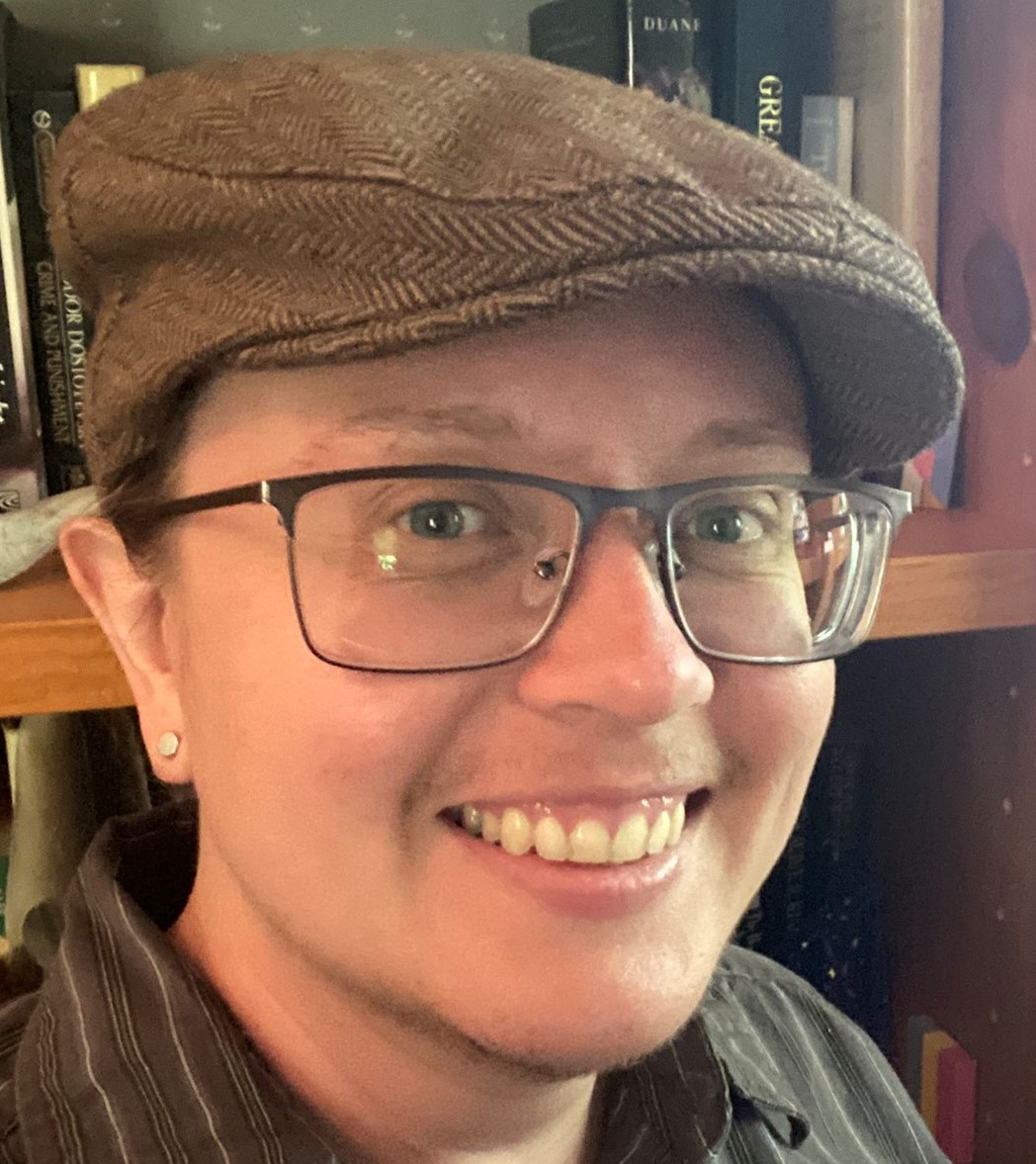 A photo of a smiling person wearing a brown hat.